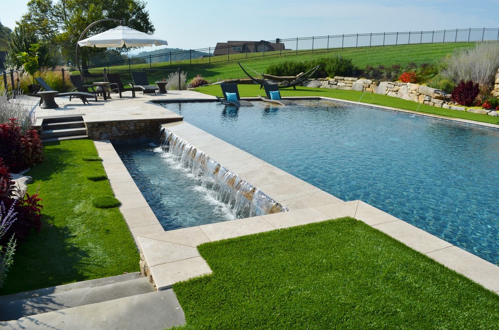 Foto de piscinas y jacuzzis alargados contemporáneos grandes rectangulares en patio trasero con adoquines de piedra natural