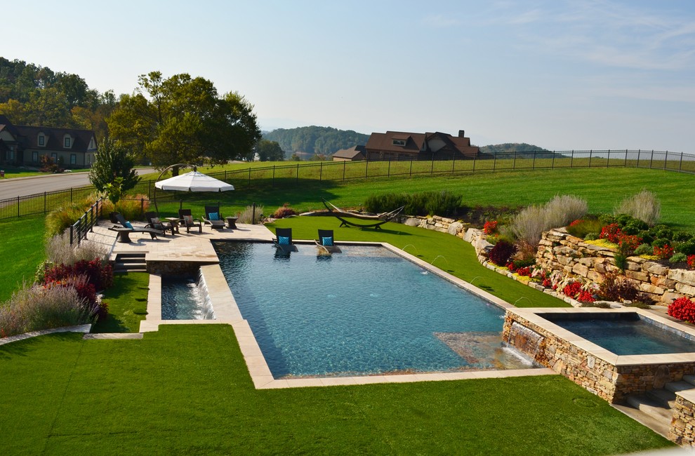 Imagen de piscinas y jacuzzis alargados contemporáneos grandes rectangulares en patio trasero con adoquines de piedra natural