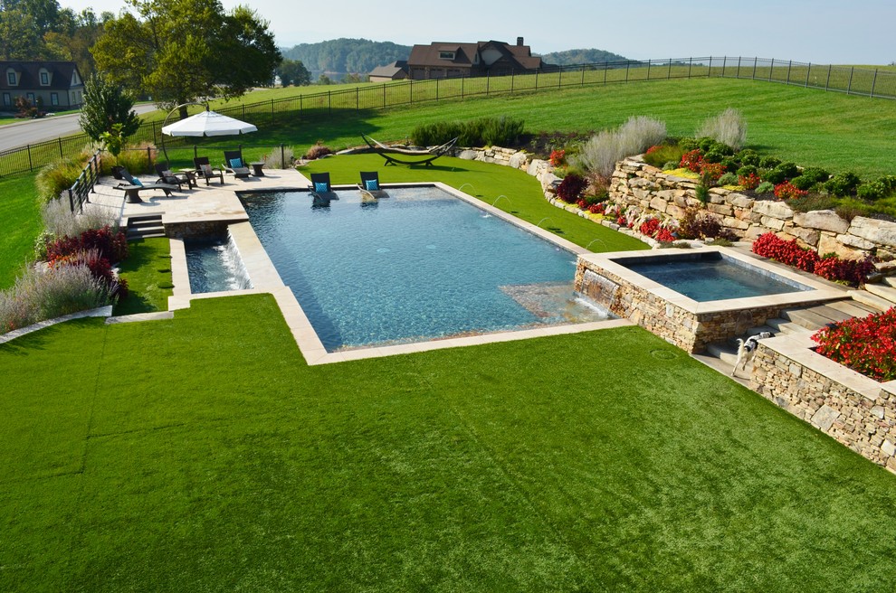 Diseño de piscinas y jacuzzis alargados actuales grandes rectangulares en patio trasero con adoquines de piedra natural