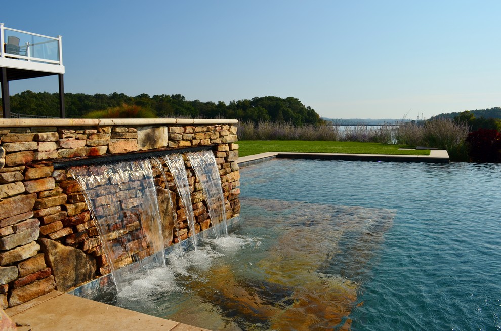 Inspiration pour un grand couloir de nage arrière design rectangle avec un bain bouillonnant et des pavés en pierre naturelle.