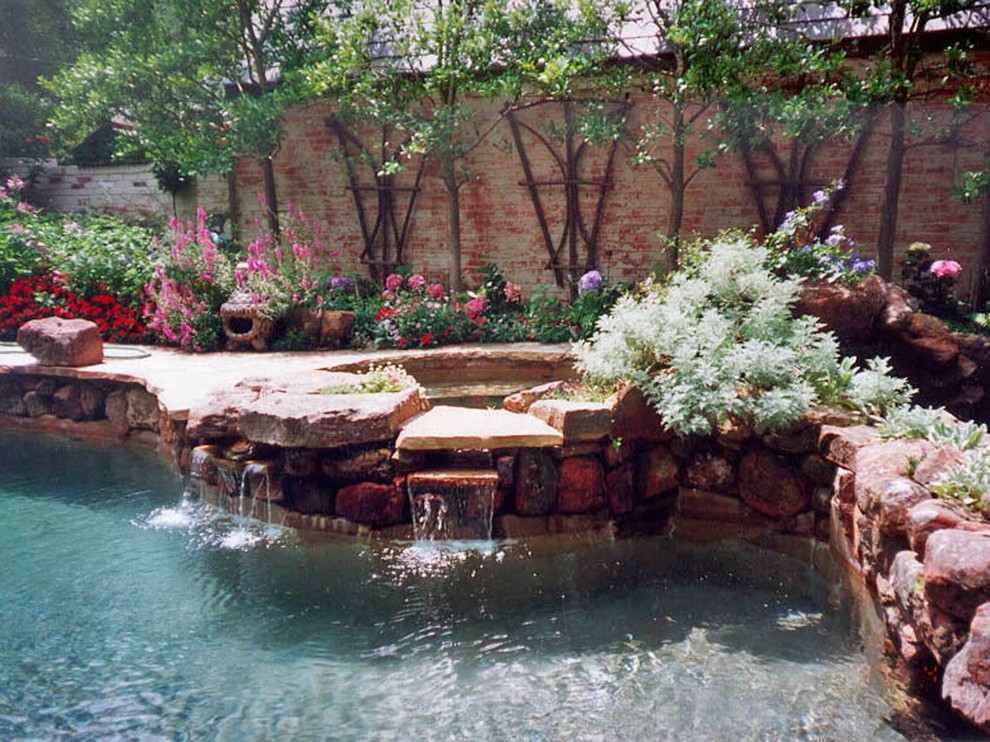 Réalisation d'une piscine naturelle et arrière bohème sur mesure avec des pavés en pierre naturelle et un point d'eau.
