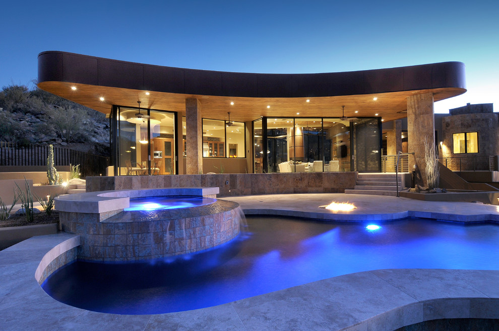 На фото: бассейн в форме фасоли, среднего размера на заднем дворе в современном стиле с джакузи и покрытием из бетонных плит