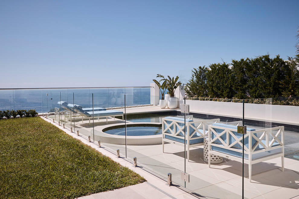 Ispirazione per una grande piscina monocorsia stile marino rettangolare dietro casa con una vasca idromassaggio