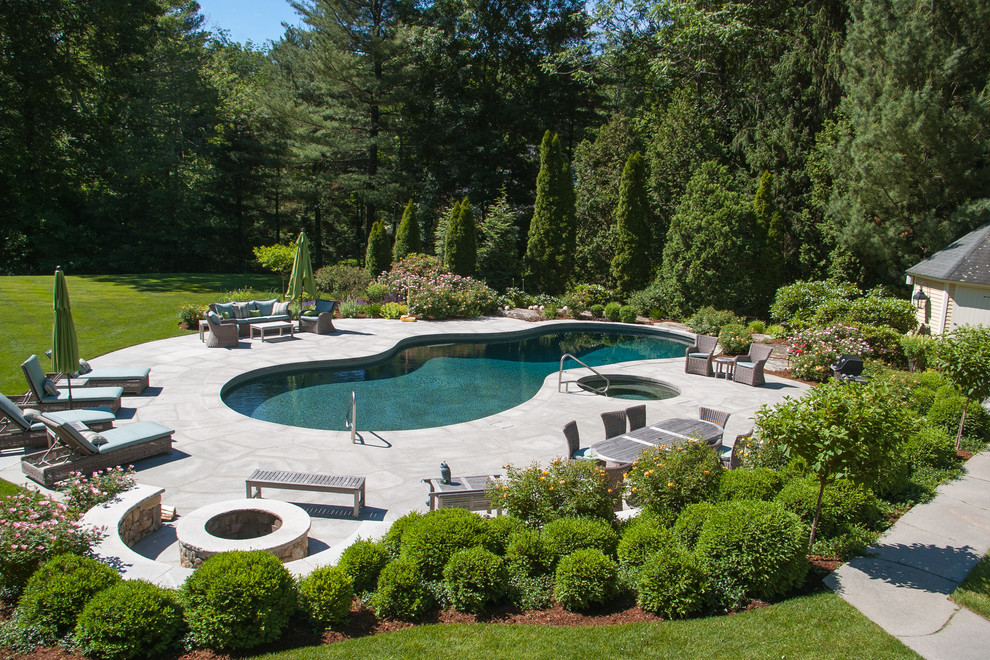Immagine di una grande piscina classica personalizzata dietro casa con una vasca idromassaggio e pavimentazioni in pietra naturale
