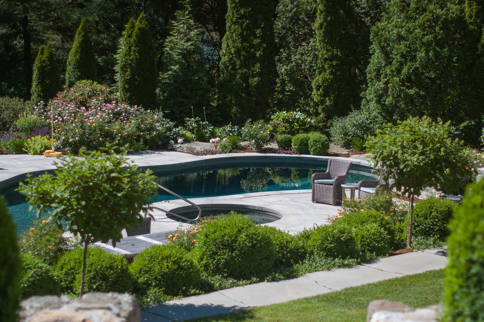 Imagen de piscinas y jacuzzis clásicos grandes a medida en patio trasero con adoquines de piedra natural