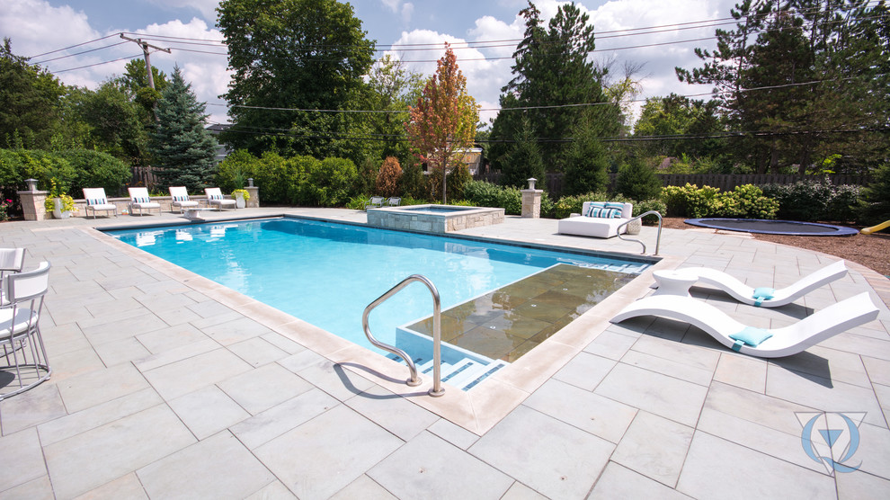 Imagen de piscina alargada tradicional grande rectangular en patio trasero con adoquines de hormigón
