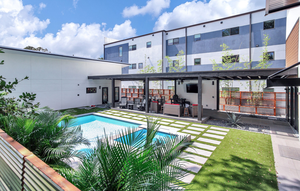 Esempio di una piscina industriale personalizzata di medie dimensioni e dietro casa con pavimentazioni in cemento