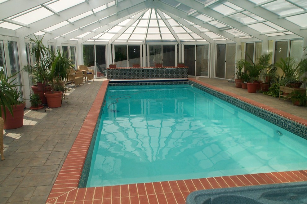 Photo of a medium sized classic indoor rectangular swimming pool in Other with a pool house and stamped concrete.