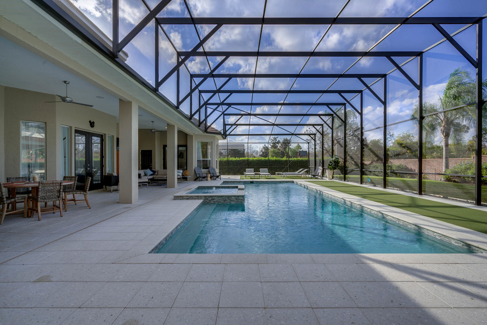 Ispirazione per una grande piscina monocorsia classica rettangolare dietro casa con una vasca idromassaggio e pavimentazioni in cemento