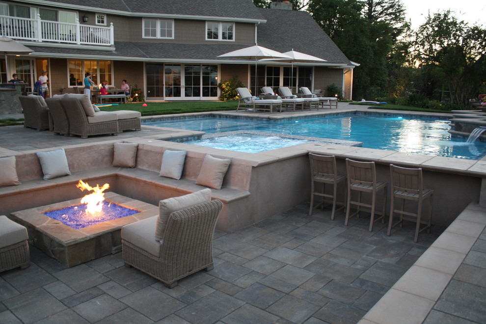 Inspiration for an expansive contemporary back custom shaped lengths hot tub in Los Angeles with natural stone paving.