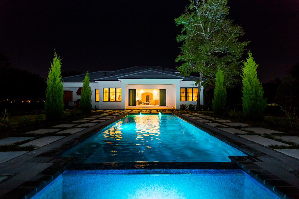 Foto de piscina elevada tradicional grande rectangular en patio trasero con adoquines de hormigón