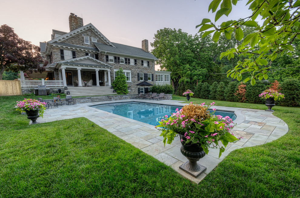 Schwimmteich hinter dem Haus in rechteckiger Form mit Natursteinplatten in Wilmington