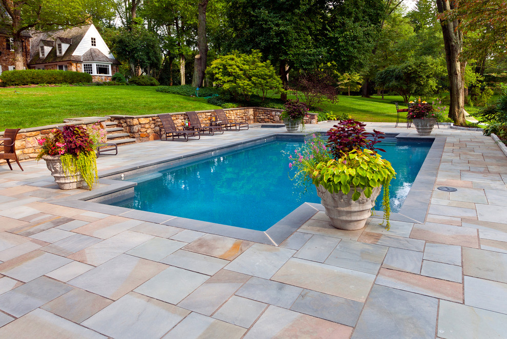 Diseño de piscinas y jacuzzis naturales rectangulares en patio trasero con adoquines de piedra natural