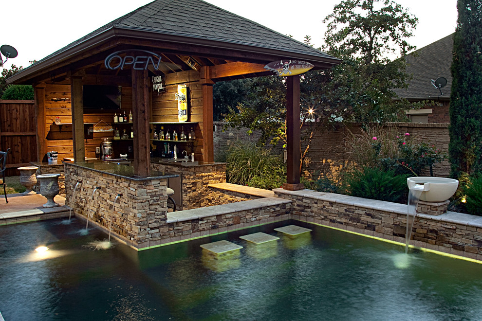 Rustic swimming pool in Dallas with a bar area.