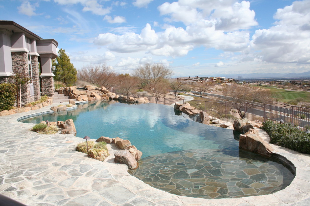 Example of a mid-sized classic backyard stone and custom-shaped natural pool fountain design in Las Vegas