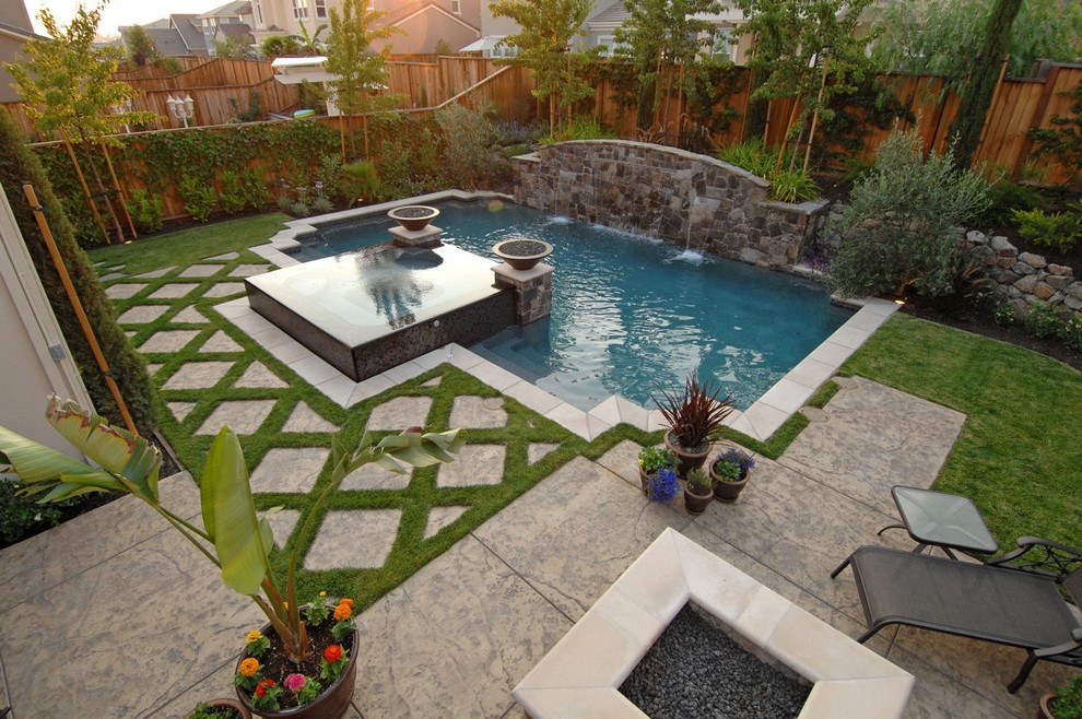 Modelo de piscinas y jacuzzis alargados clásicos de tamaño medio a medida en patio trasero con adoquines de piedra natural