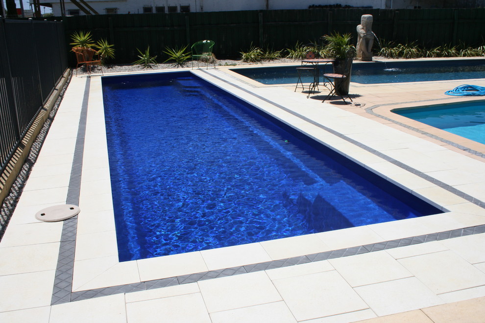 Ejemplo de piscina alargada contemporánea grande rectangular en patio trasero