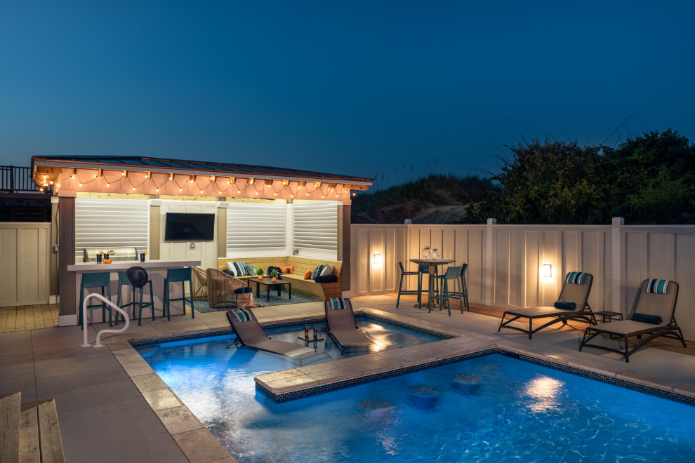 Ejemplo de casa de la piscina y piscina costera grande rectangular en patio trasero con losas de hormigón