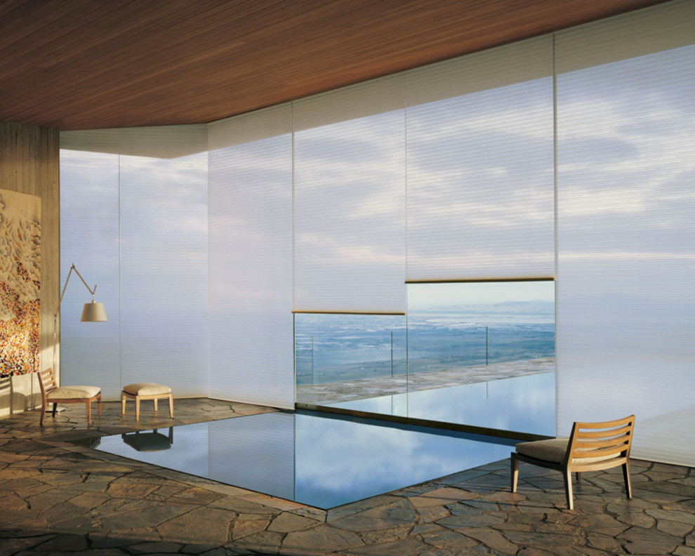 На фото: большой прямоугольный бассейн в доме в стиле модернизм с домиком у бассейна и покрытием из каменной брусчатки с