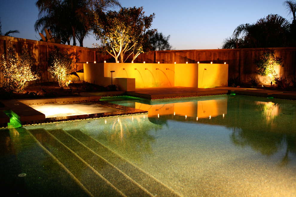 Design ideas for a large contemporary back custom shaped swimming pool in San Diego with a water feature.