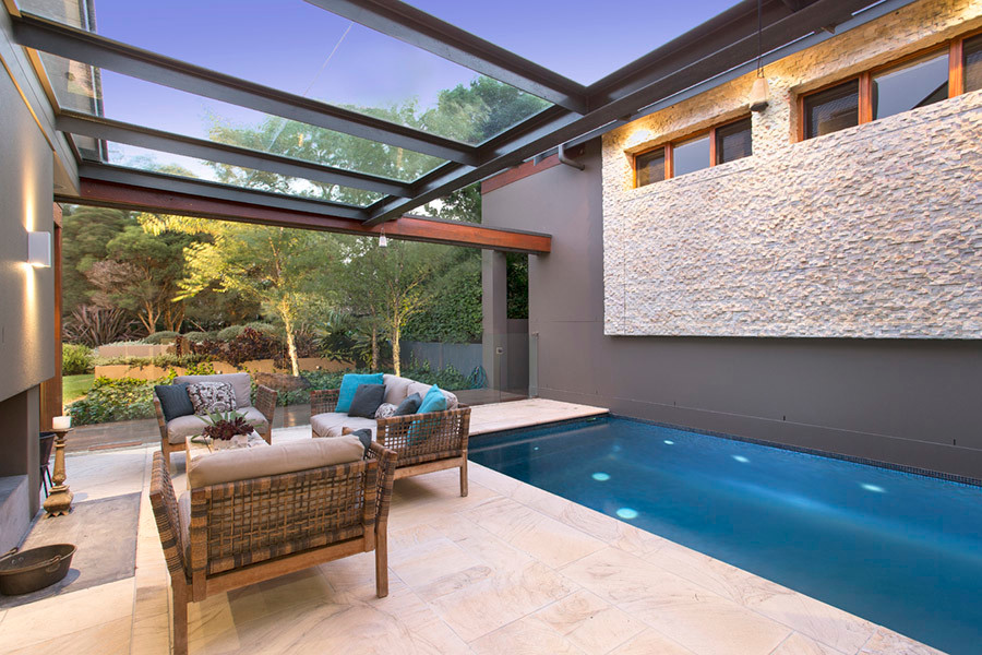 Expansive contemporary custom shaped swimming pool in Sydney with natural stone paving.