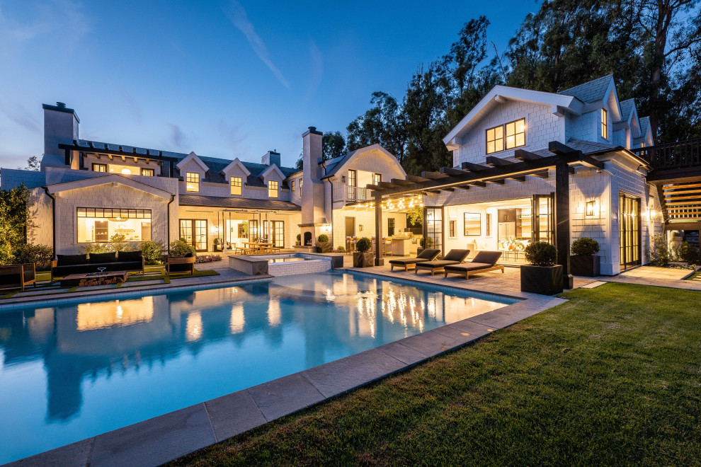 Pool house - large coastal backyard concrete paver and rectangular pool house idea in Los Angeles