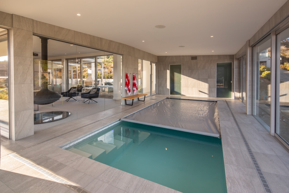 Пример оригинального дизайна: большой естественный, прямоугольный бассейн в доме в стиле модернизм с домиком у бассейна