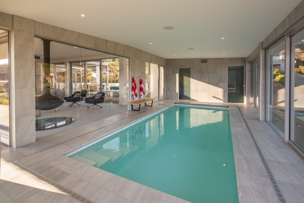 Esempio di una grande piscina coperta naturale moderna rettangolare con una dépendance a bordo piscina