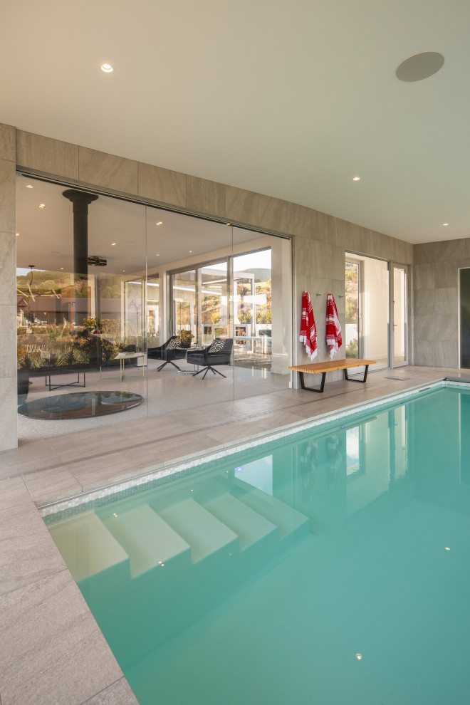 Photo of a large modern indoor rectangular natural swimming pool in Dunedin with a pool house.