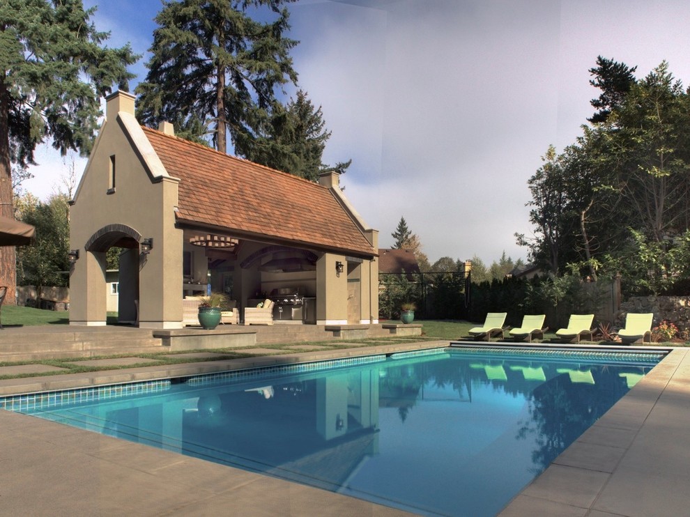Immagine di una grande piscina naturale tradizionale rettangolare dietro casa con una dépendance a bordo piscina e lastre di cemento