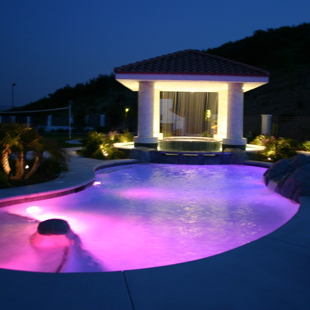Esempio di una piscina minimalista personalizzata di medie dimensioni e dietro casa con un acquascivolo e lastre di cemento