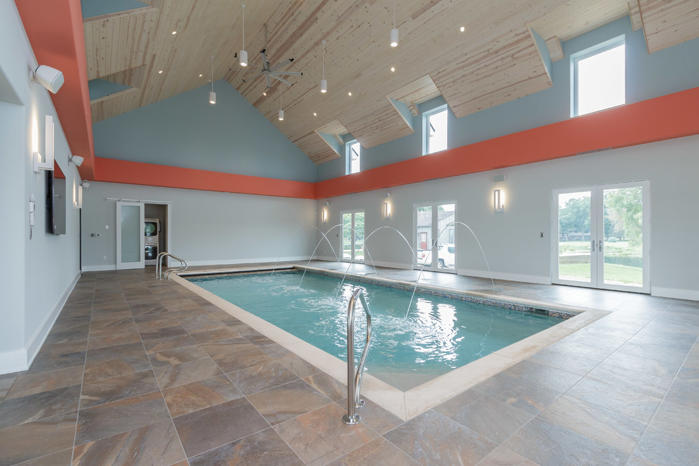 Idee per una grande piscina coperta monocorsia design rettangolare con fontane e piastrelle