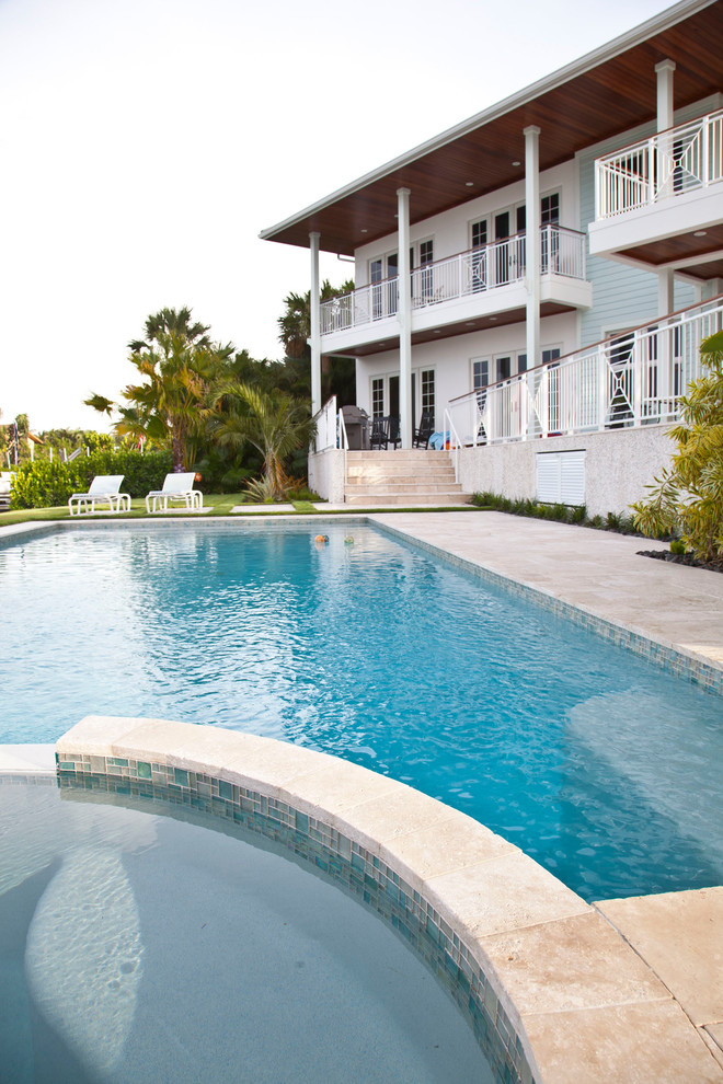 Ejemplo de piscina exótica de tamaño medio en patio delantero con adoquines de hormigón