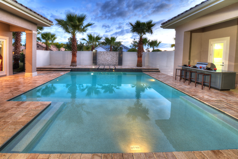 Esempio di una piscina design rettangolare di medie dimensioni e in cortile con fontane e graniglia di granito