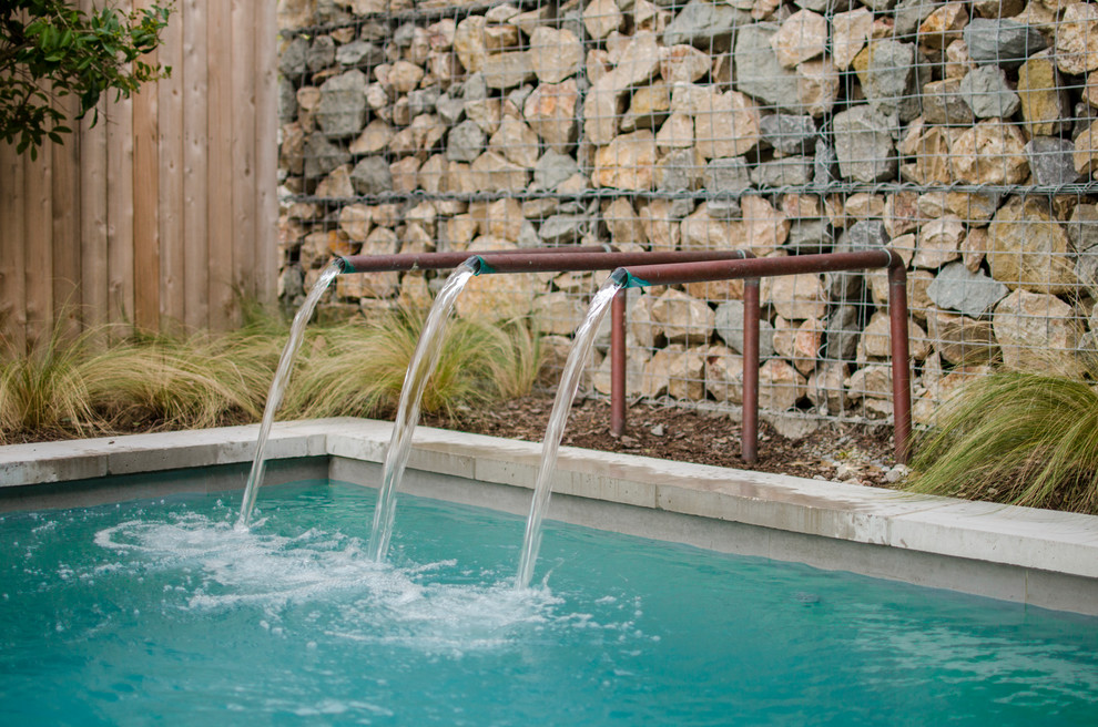 ダラスにある低価格の小さなインダストリアルスタイルのおしゃれなプール (噴水、コンクリート板舗装	) の写真