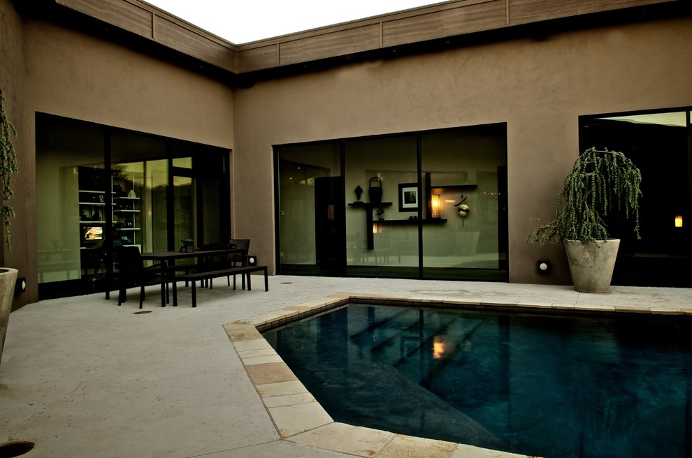 Design ideas for a small world-inspired back custom shaped lengths swimming pool in Oklahoma City with concrete slabs.