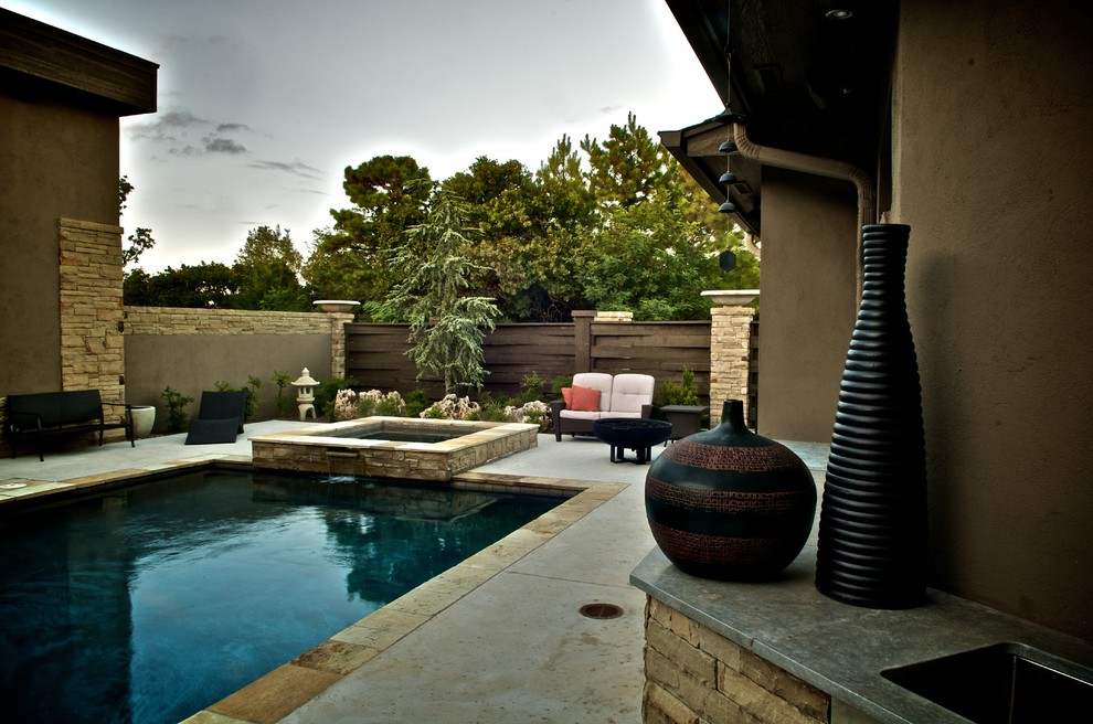 Ejemplo de piscinas y jacuzzis alargados asiáticos pequeños rectangulares en patio trasero con losas de hormigón