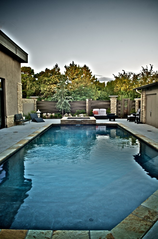 Modelo de piscinas y jacuzzis alargados asiáticos pequeños rectangulares en patio trasero con losas de hormigón