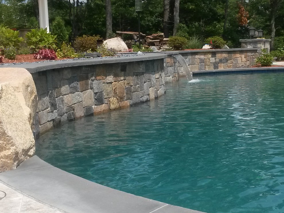 This is an example of an expansive rustic back custom shaped natural hot tub in Boston with natural stone paving.