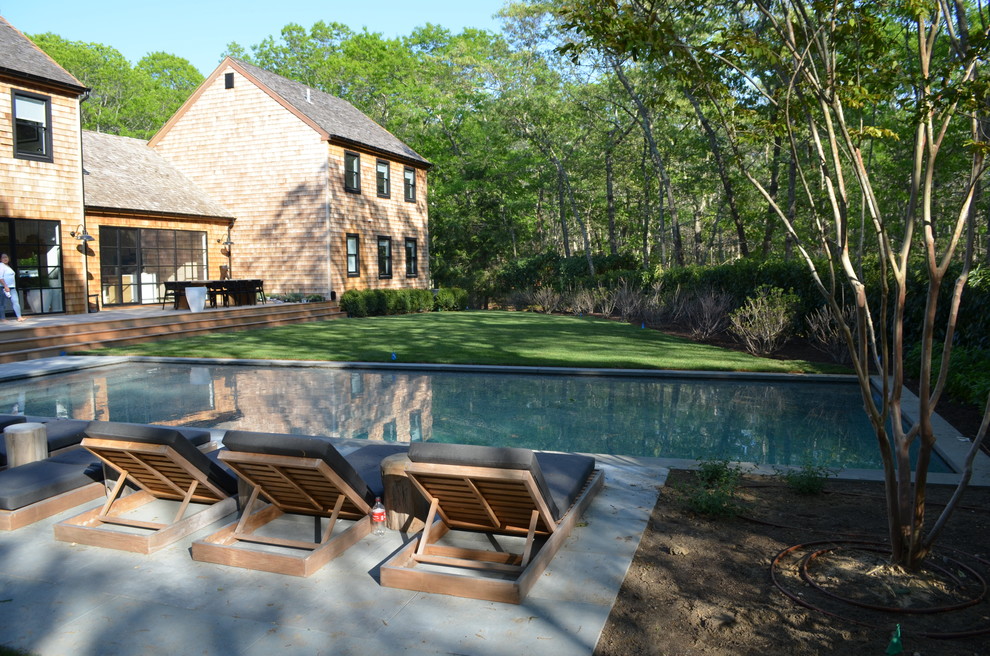 This is an example of a large traditional back rectangular lengths swimming pool in New York with concrete paving.