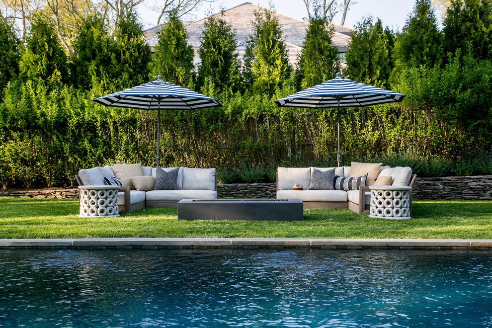 Imagen de piscina natural costera grande rectangular en patio trasero con adoquines de piedra natural