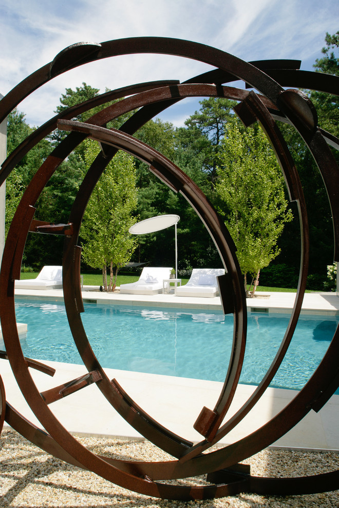 Diseño de piscina alargada campestre de tamaño medio rectangular en patio trasero