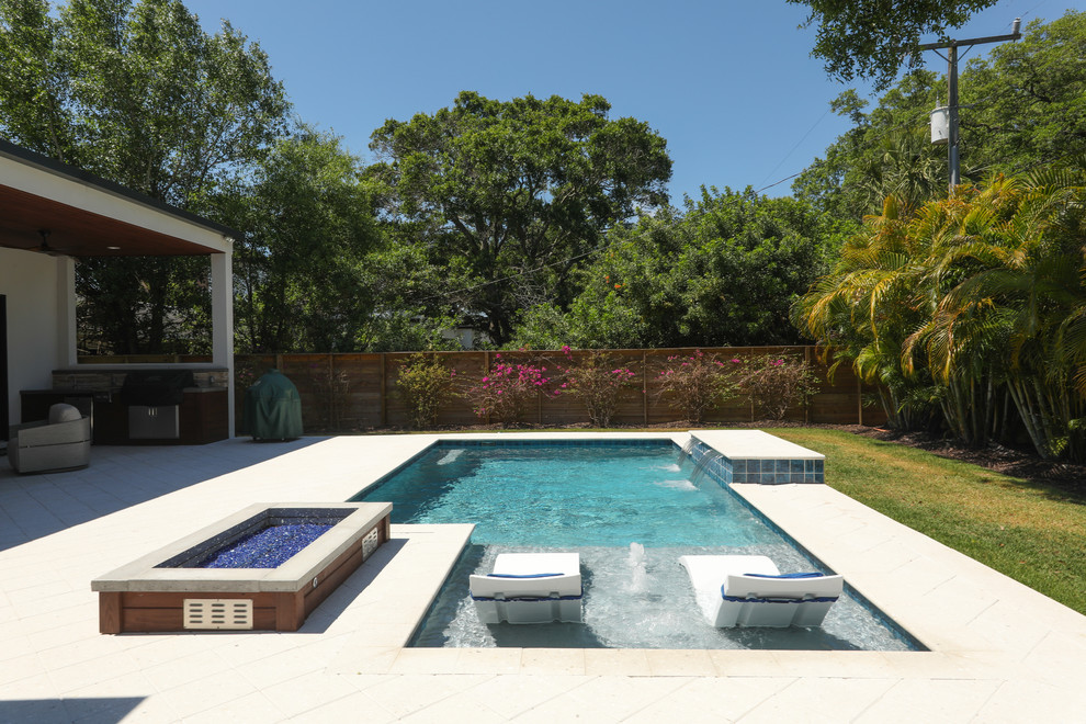 Example of a mid-sized beach style backyard stone and rectangular natural pool fountain design in Tampa