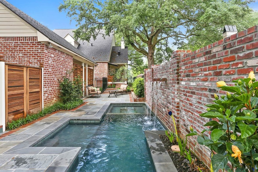 Pool fountain - small traditional side yard stone and rectangular pool fountain idea in New Orleans