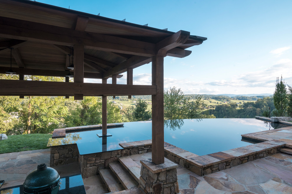 Inspiration for a rustic backyard tile and custom-shaped infinity pool remodel in Other