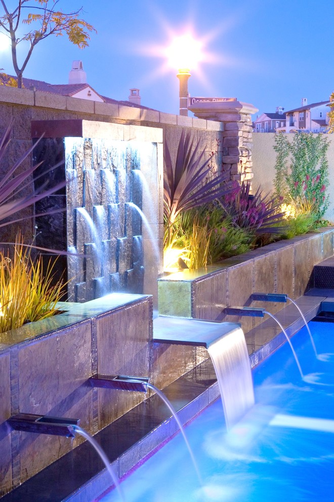 Idee per una piccola piscina eclettica rettangolare dietro casa con fontane e piastrelle