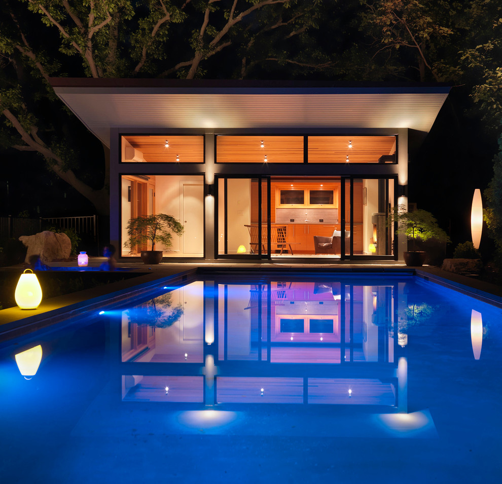 Пример оригинального дизайна: спортивный, прямоугольный бассейн среднего размера на заднем дворе в стиле модернизм с покрытием из каменной брусчатки и джакузи