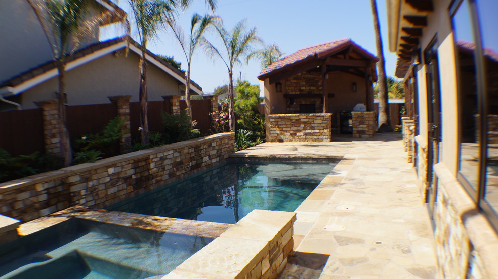 Foto de piscina con tobogán alargada clásica renovada de tamaño medio a medida en patio trasero con suelo de hormigón estampado