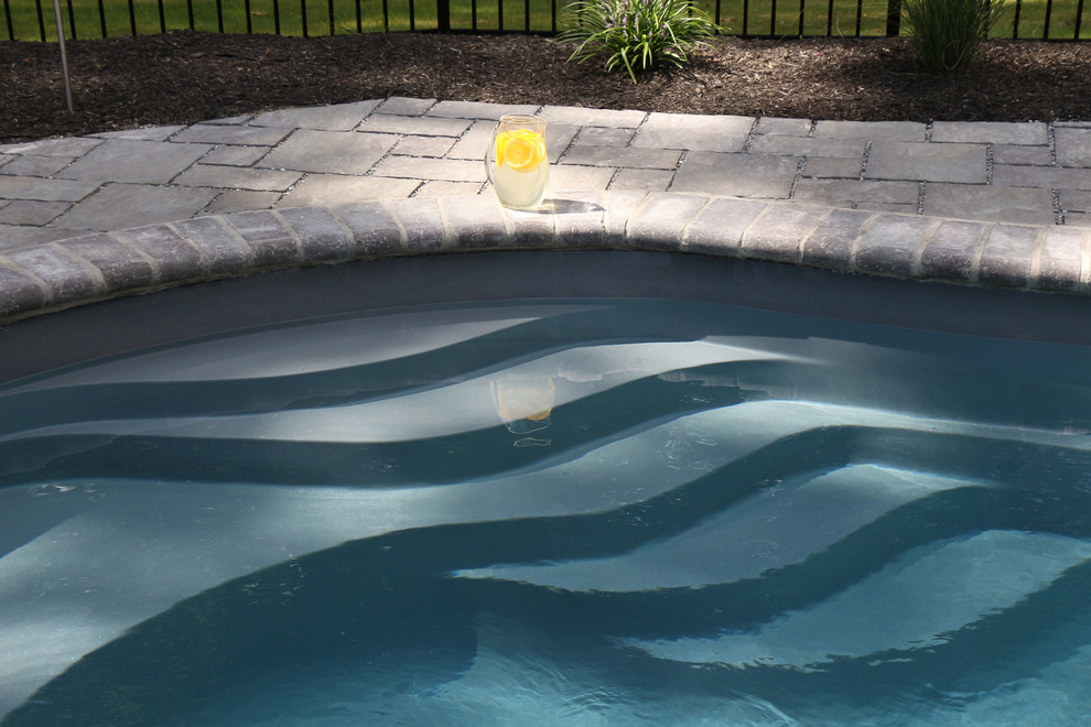 Ispirazione per una grande piscina naturale tradizionale personalizzata dietro casa con fontane e pavimentazioni in pietra naturale