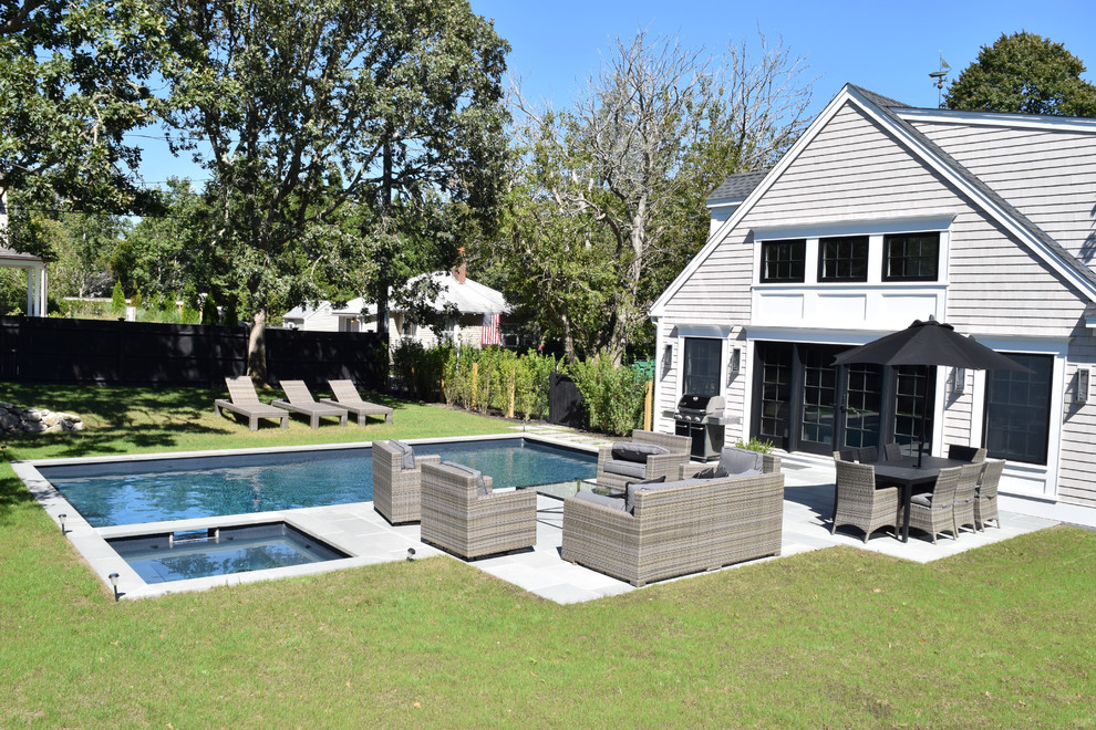 Foto de piscina alargada tradicional de tamaño medio rectangular en patio trasero con losas de hormigón